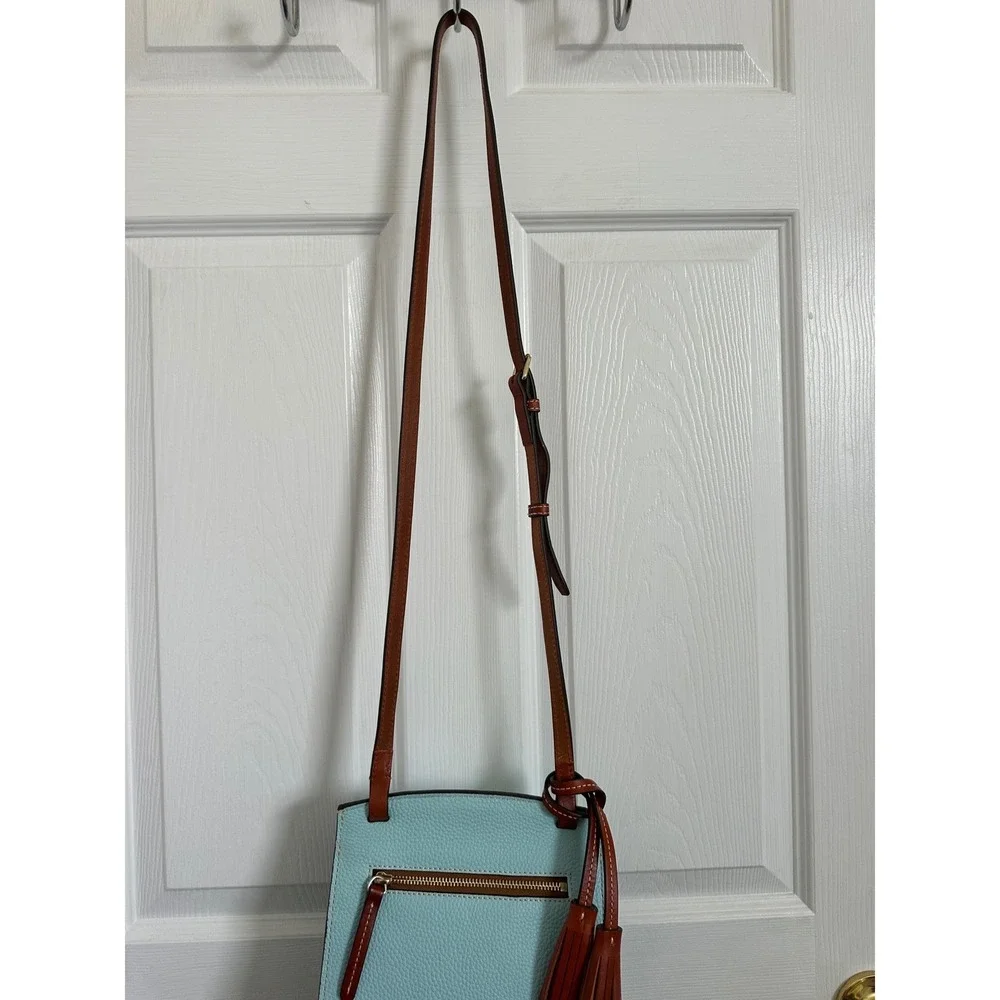 This is a Dooney & Bourke Pebble Grain East/West Flap Crossbody in a light blue